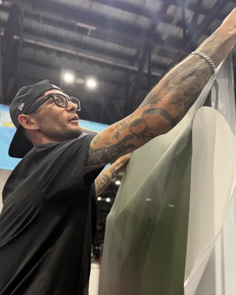 The owner of Zap Wrap Naples laying a vinyl panel by hand