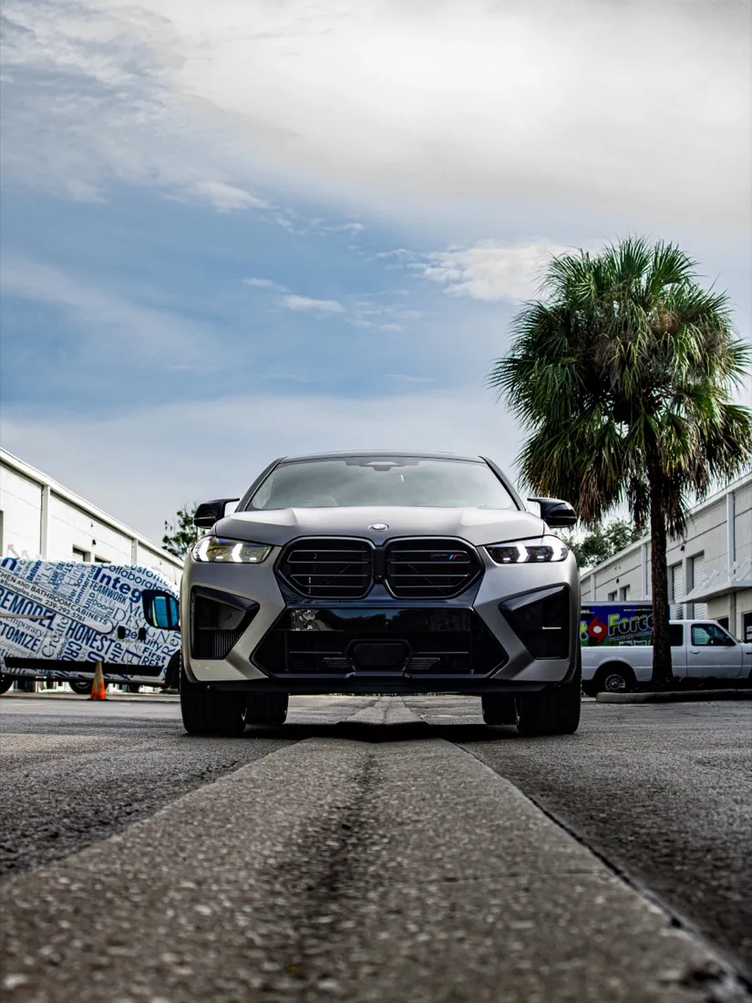 BMW X6 M Competition head-on under a Florida palm