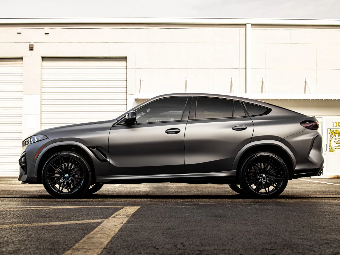 Full side profile of the matte dark gray BMW X6 M Competition